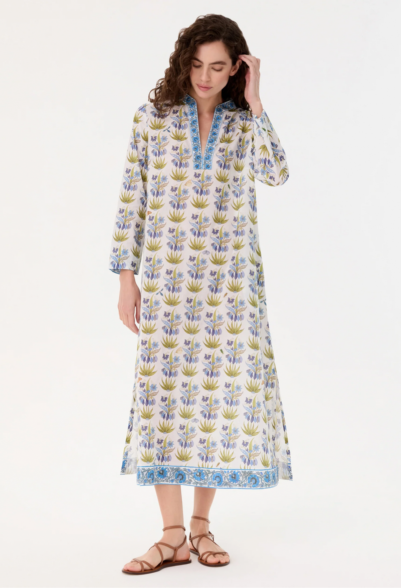 Woman wearing a long, patterned dress on a white background