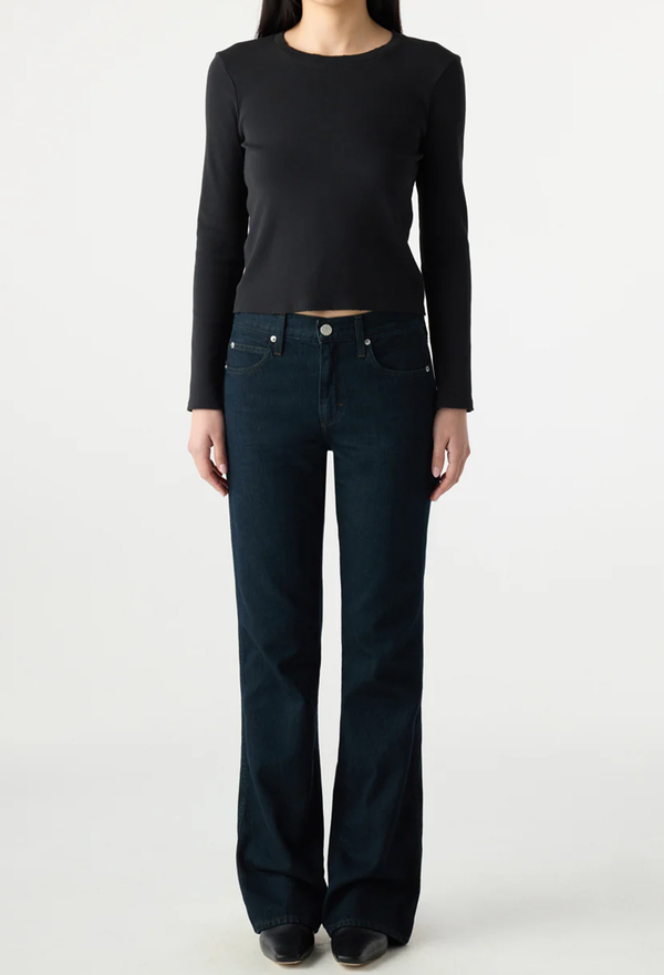 Person wearing a black long-sleeve top and dark blue jeans on a white background