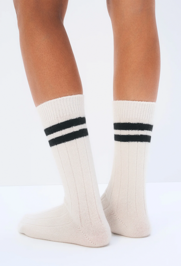White socks with black stripes worn by a person on a white background