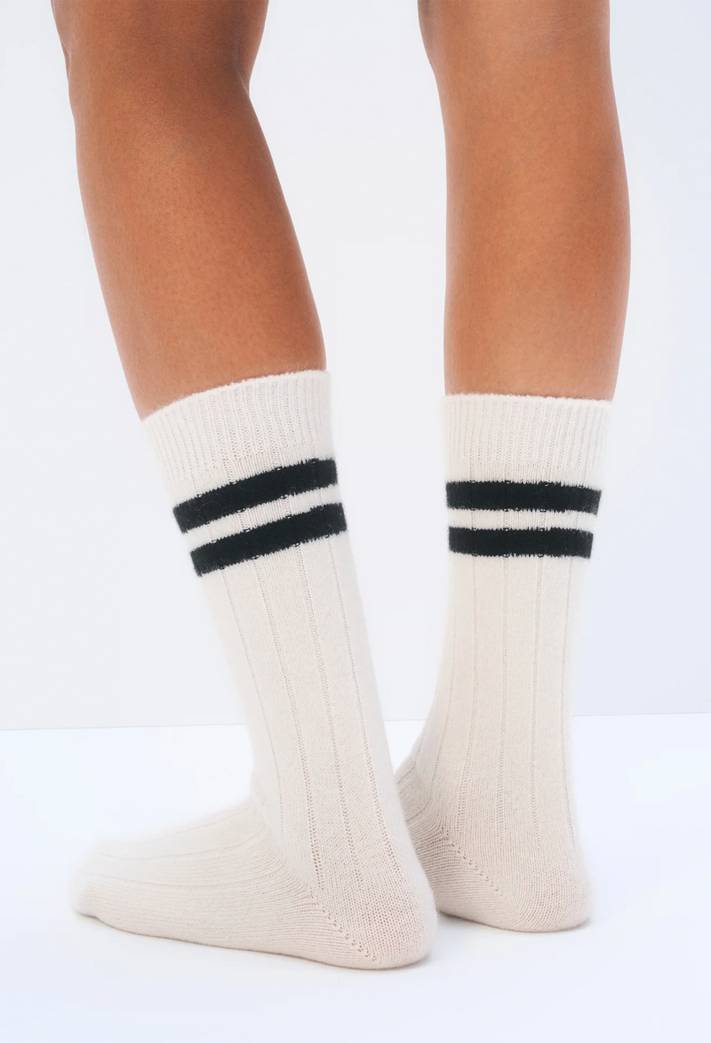 White socks with black stripes worn by a person on a white background