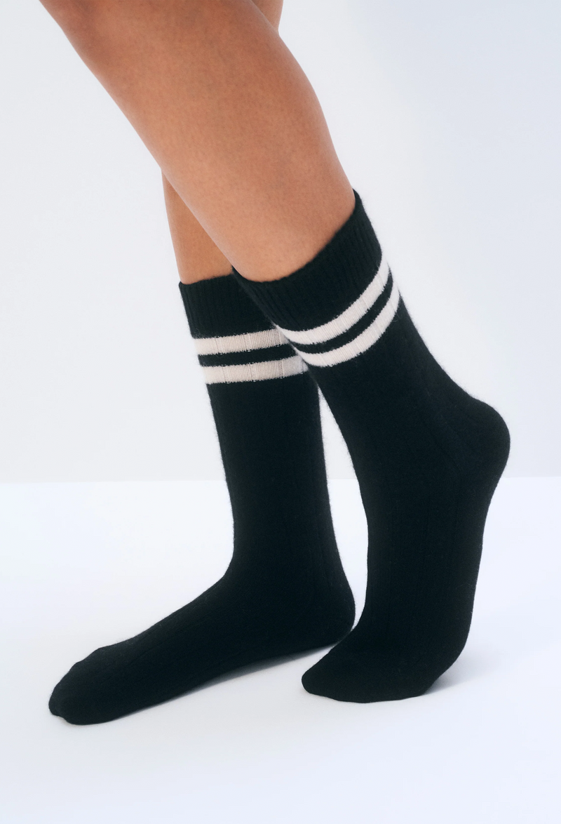 Black socks with white stripes worn by a person on a white background
