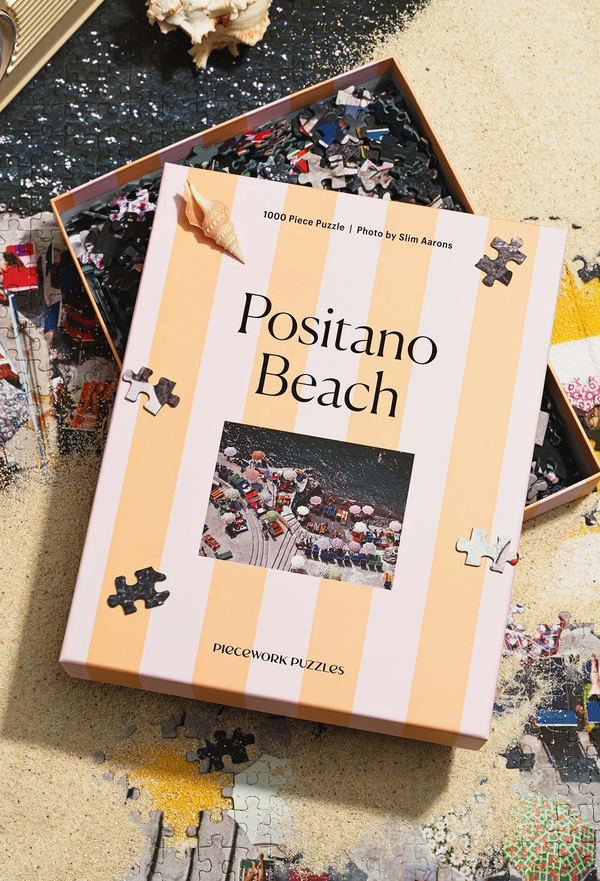 Puzzle box titled 'Positano Beach' with puzzle pieces scattered around