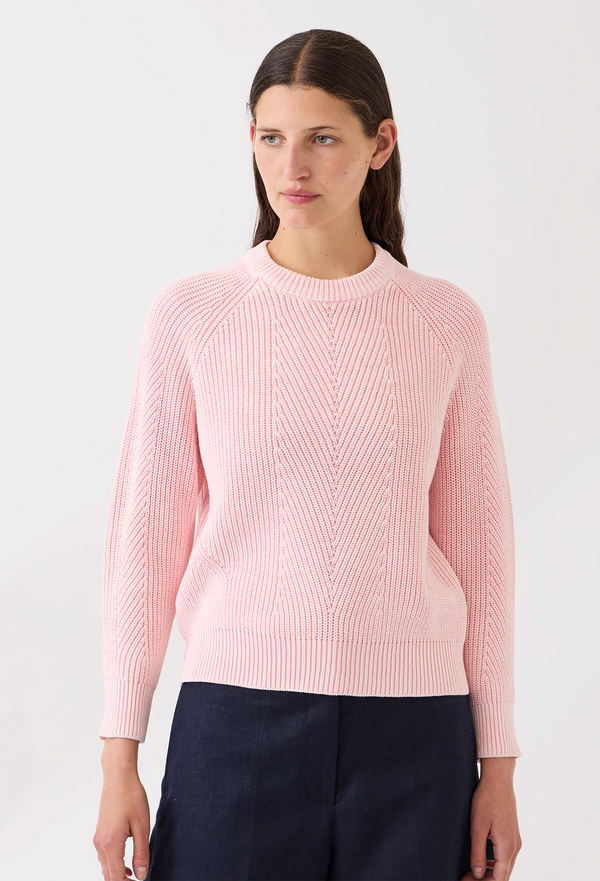 Woman wearing a pink sweater against a white background