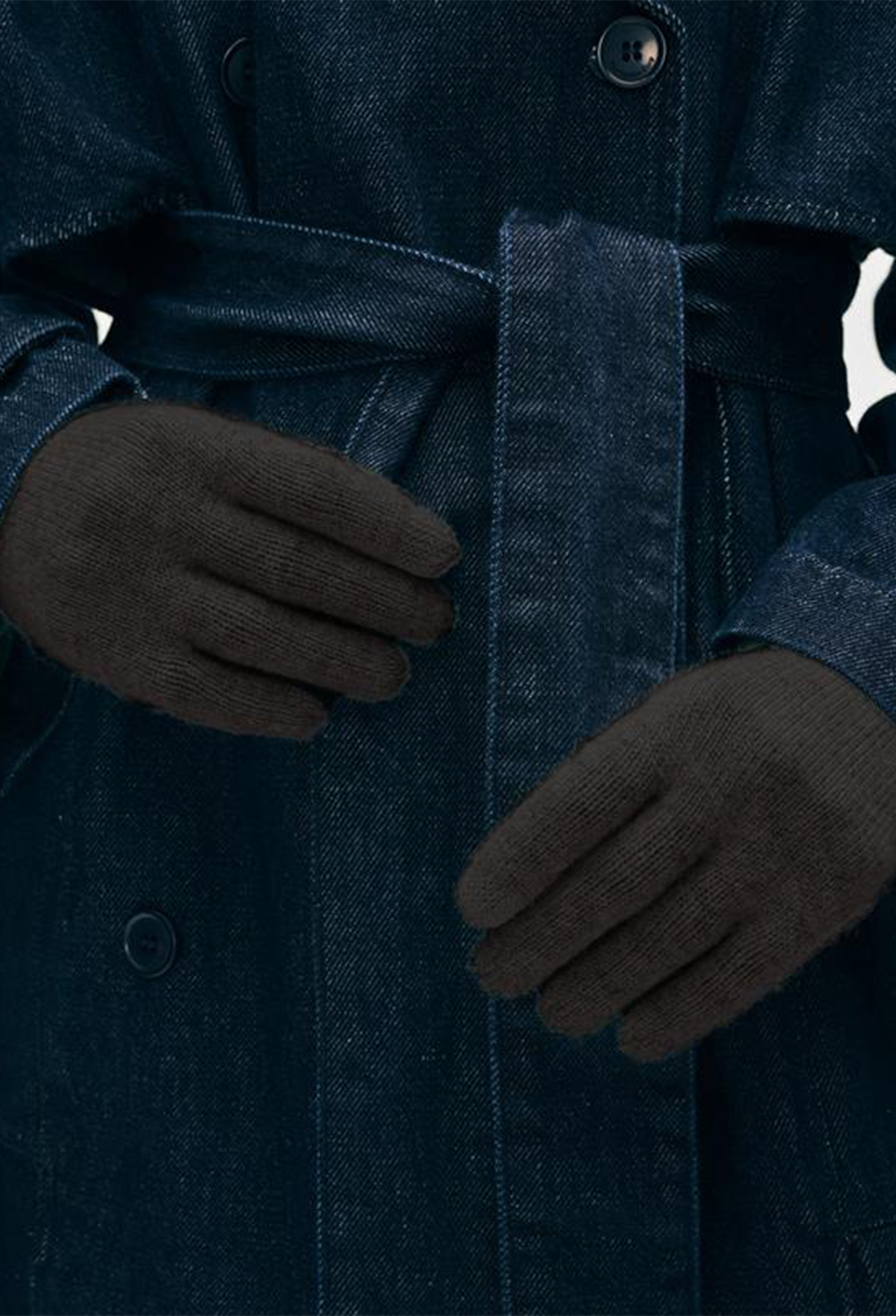 Person wearing a dark coat and black gloves