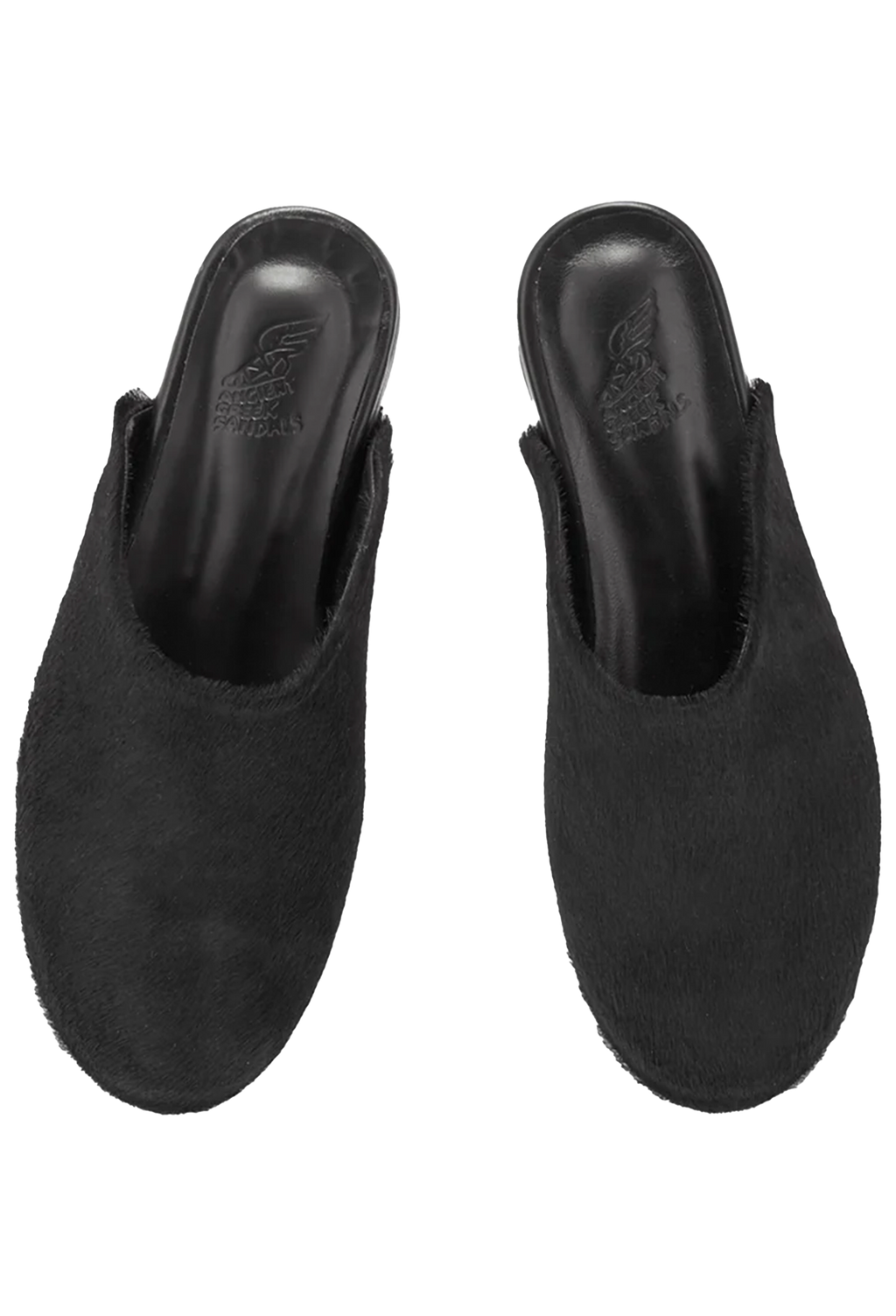 Pair of black pony hair mules on a white background