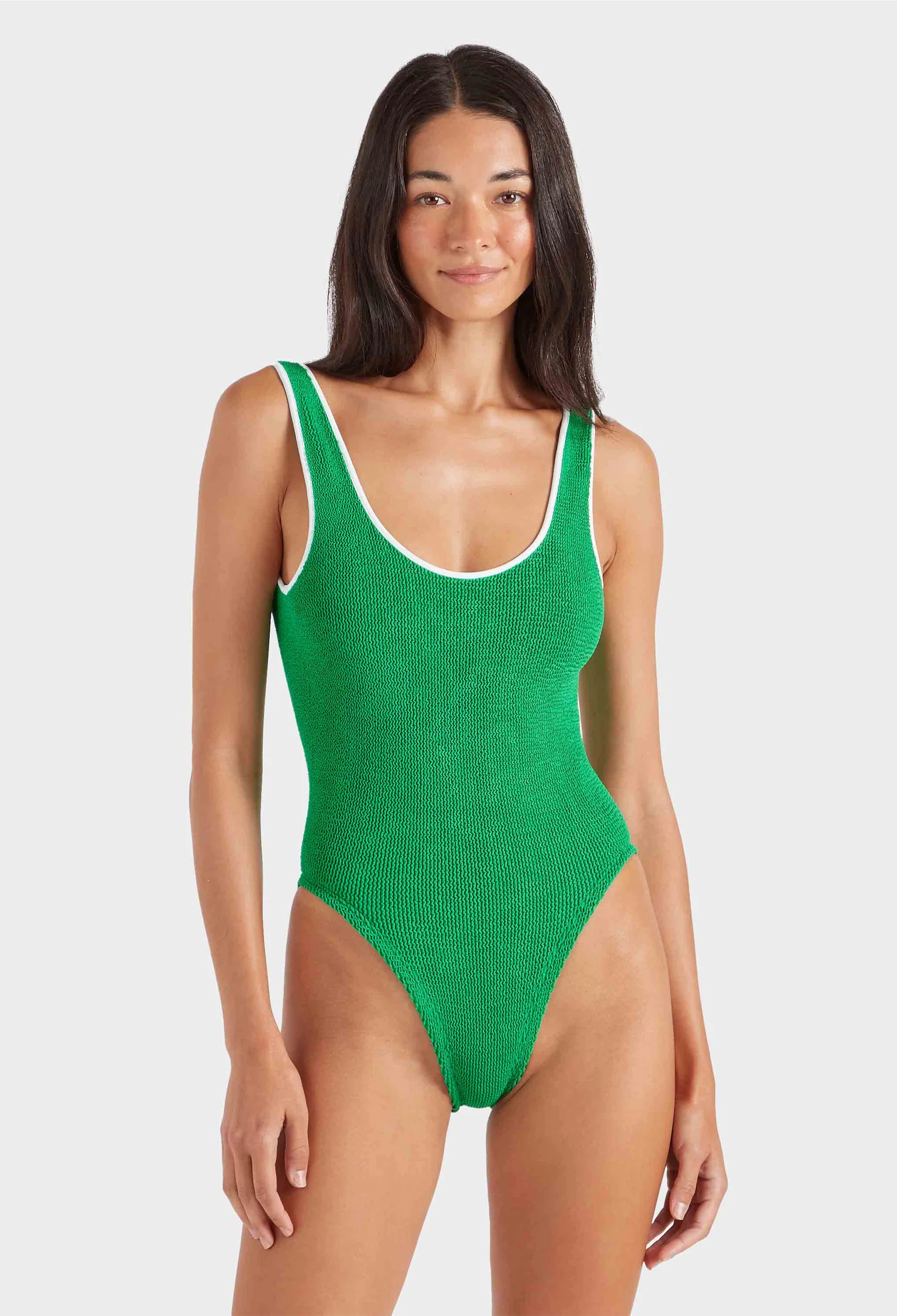 Woman wearing a green swimsuit on a white background