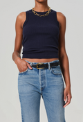 Person wearing a navy tank top and blue jeans on a plain background