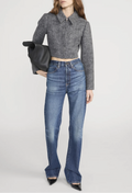 Person wearing a gray cropped sweater and blue jeans on a white background