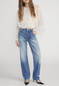 Person wearing a white blouse and blue jeans on a plain background
