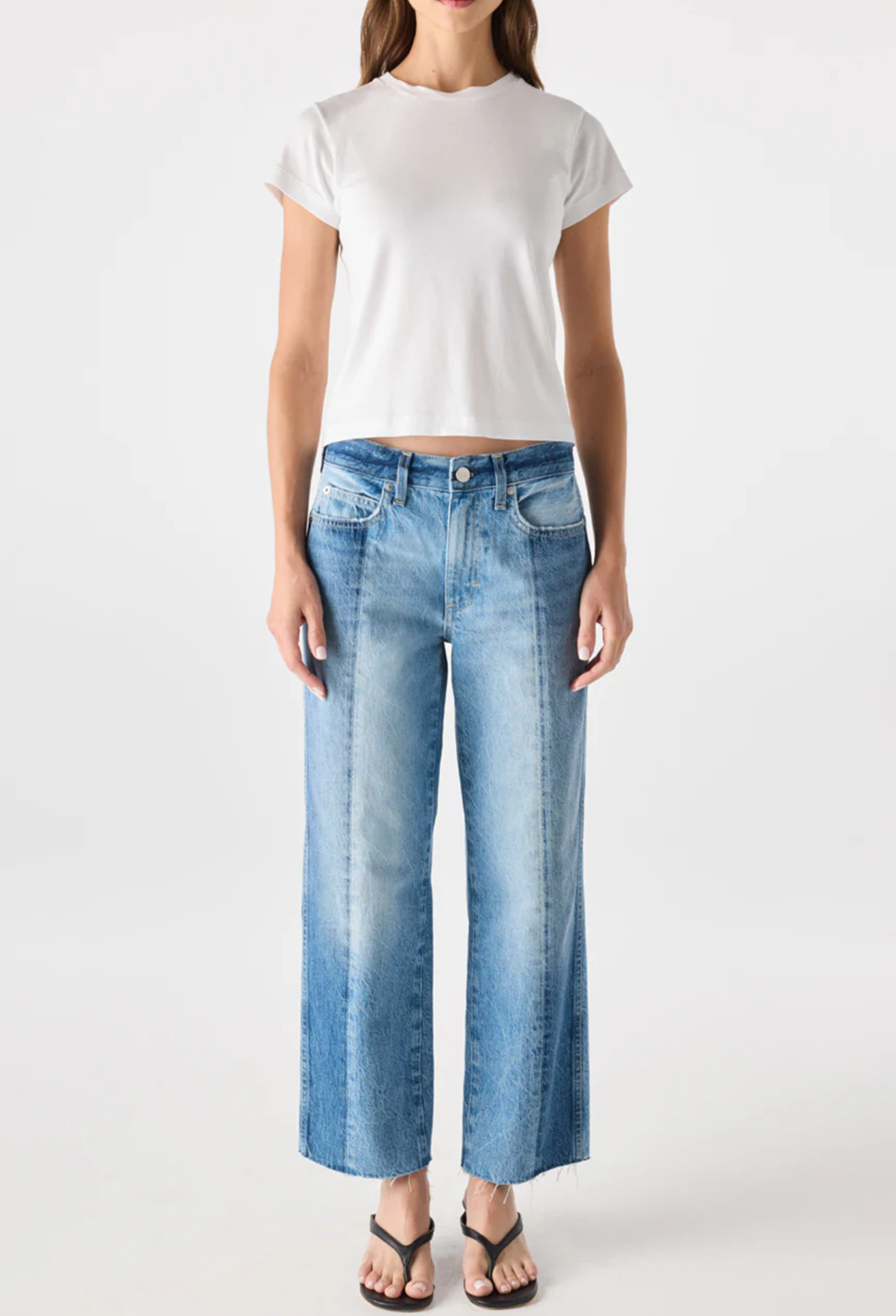 Person wearing a white t-shirt and blue jeans on a white background