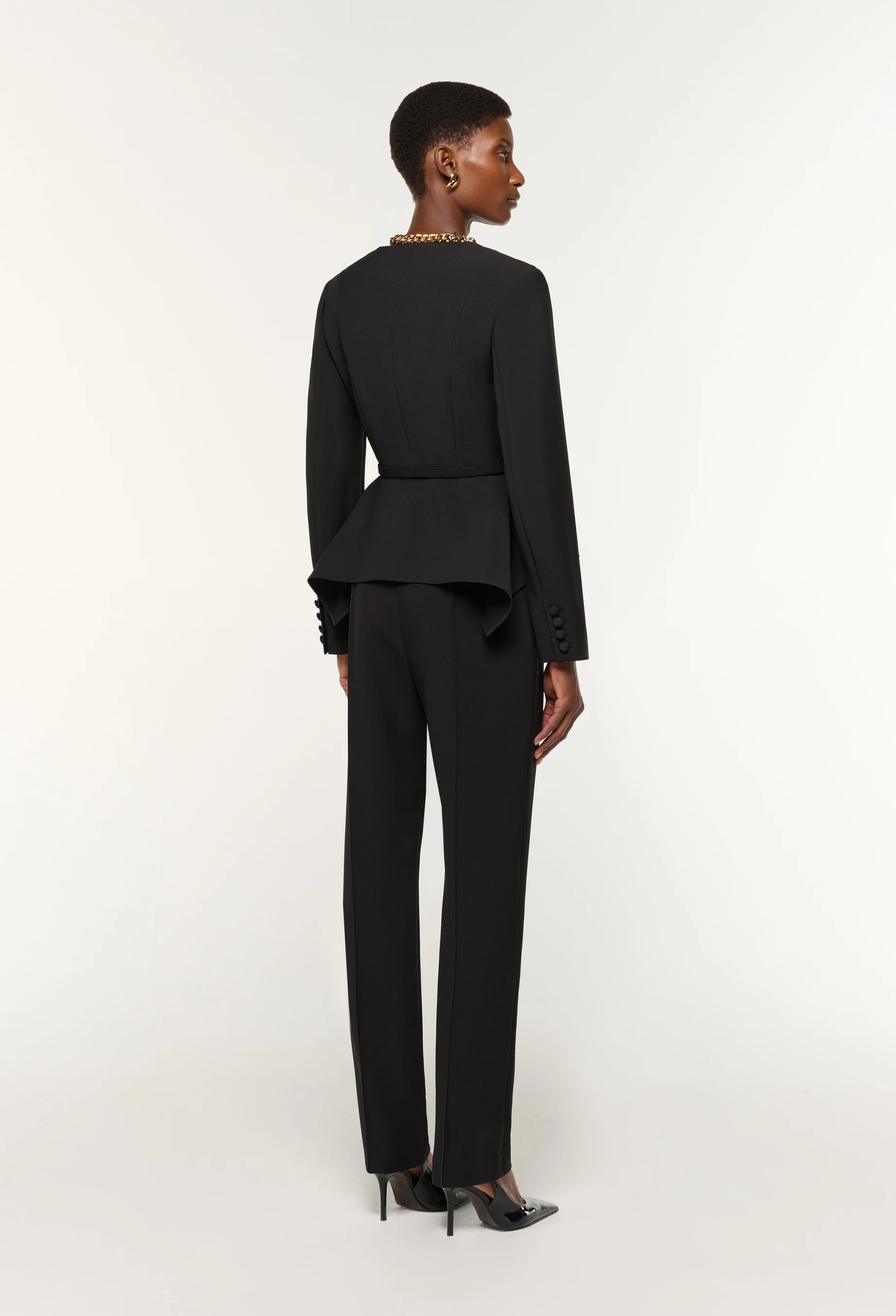 Woman wearing a black suit on a white background