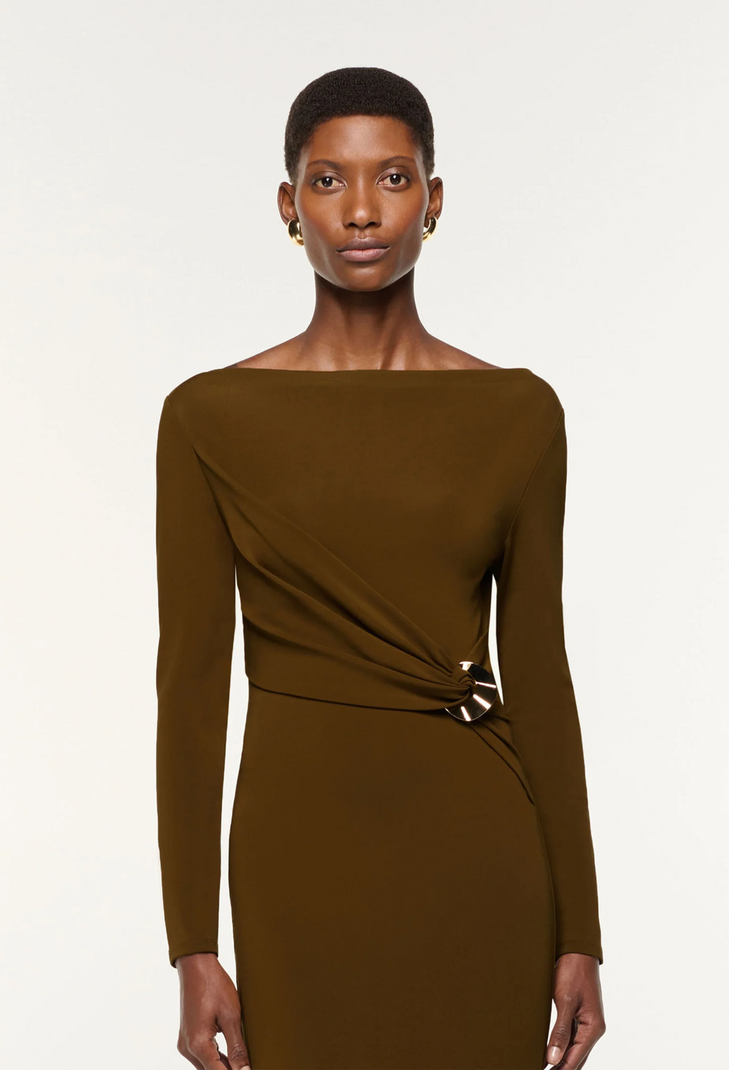 Woman wearing a brown long-sleeve dress against a white background