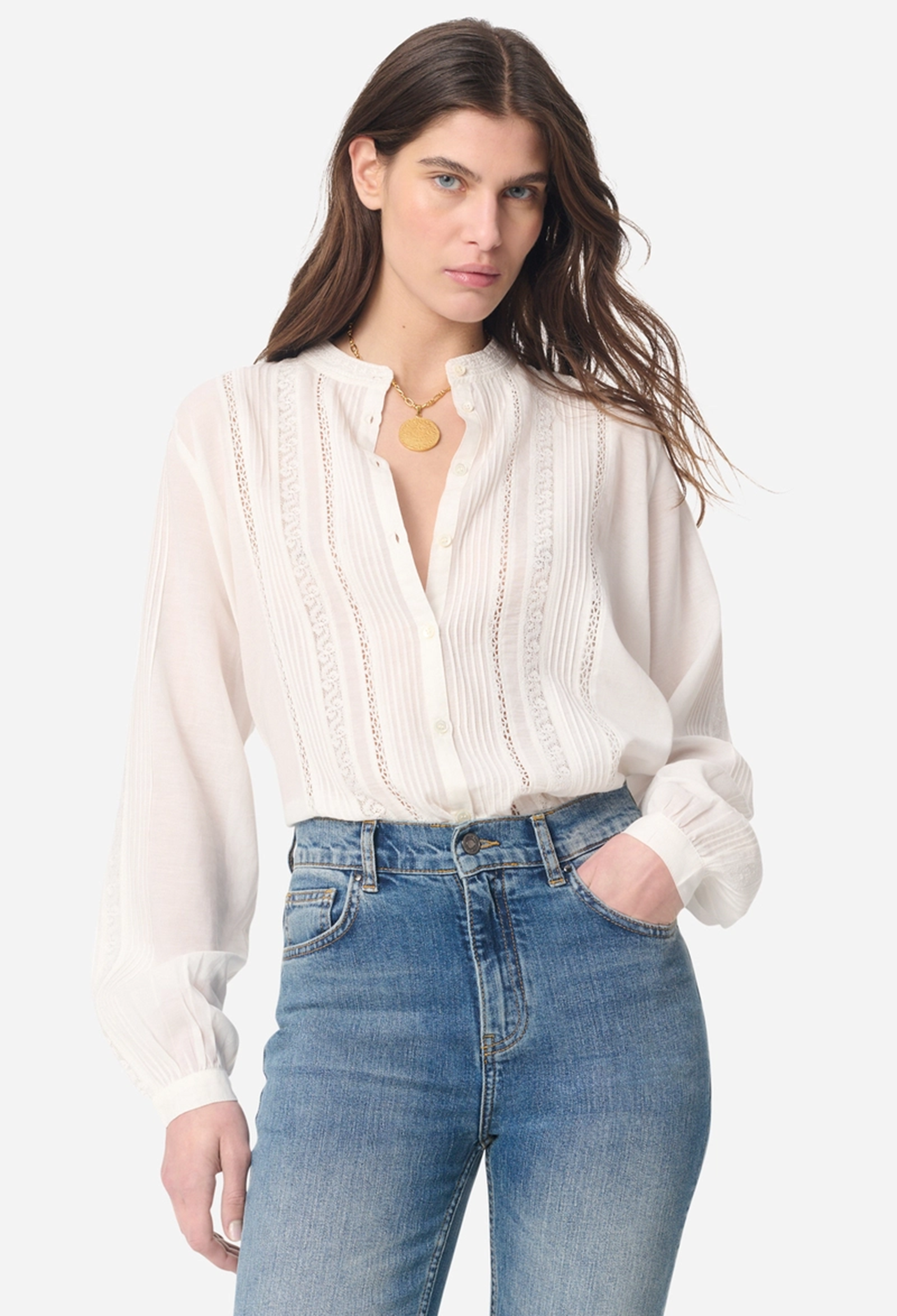 Woman wearing a white blouse and blue jeans on a white background