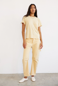 Person wearing a yellow t-shirt and pants against a white background