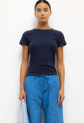 Person wearing a navy t-shirt and blue pants against a white background