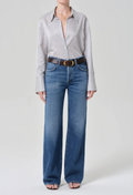 Person wearing a striped shirt and blue jeans on a white background