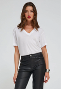 Woman wearing a white top and black leather pants on a plain background