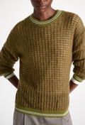 Person wearing a green and brown patterned sweater on a white background