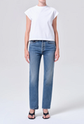 Person wearing a white t-shirt and blue jeans on a light gray background