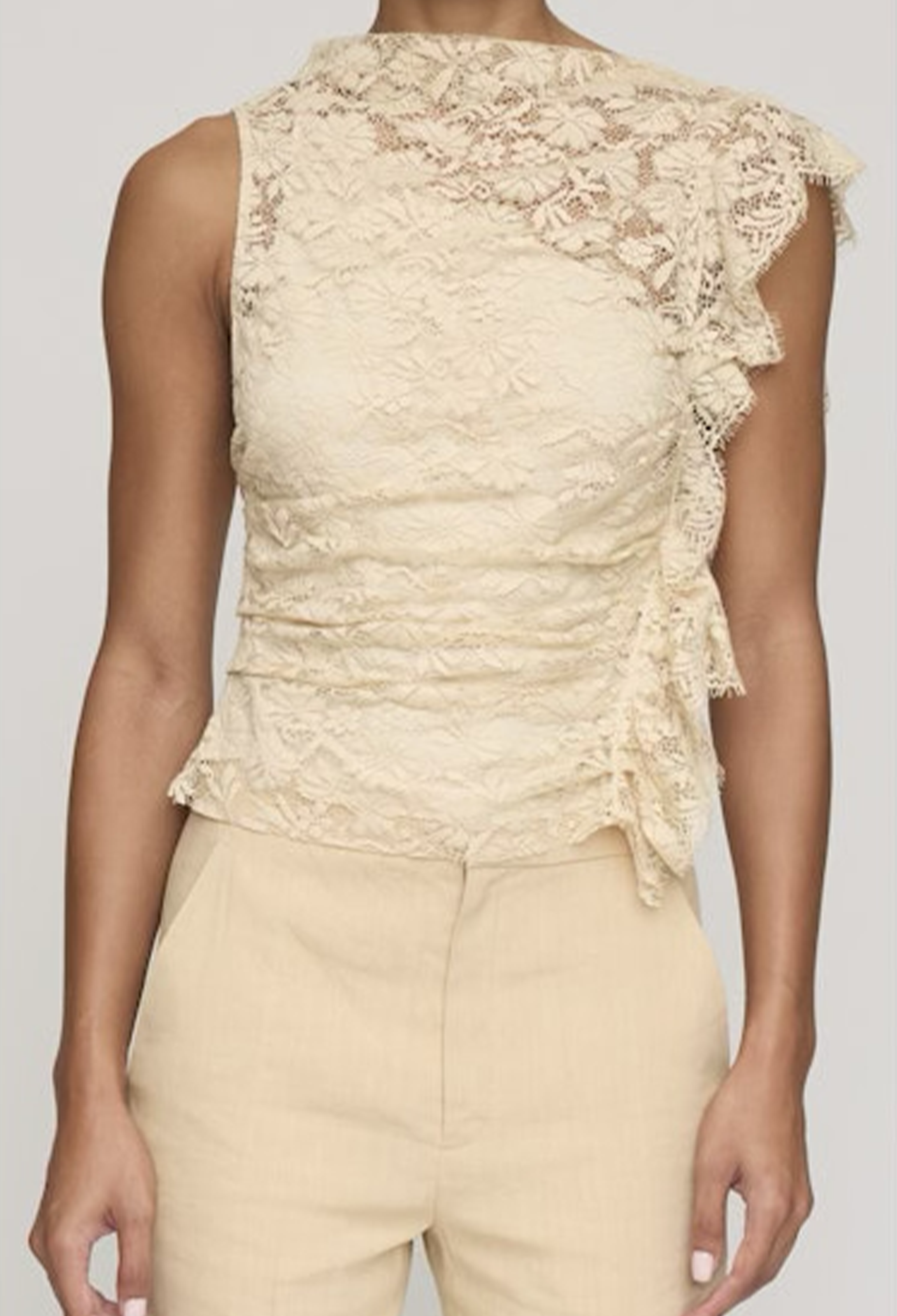 Beige lace top worn by a person on a plain background