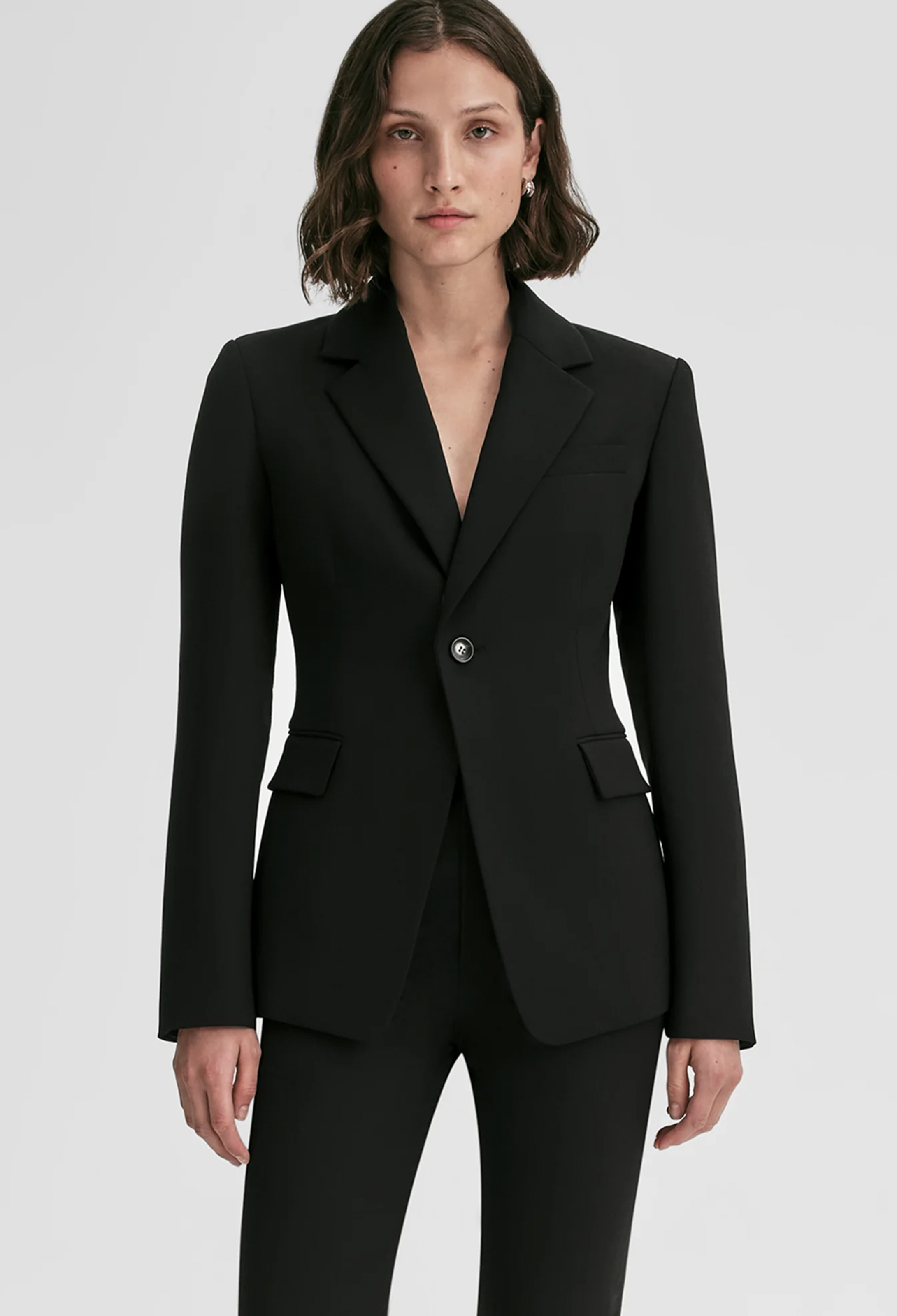 Person wearing a black suit on a white background