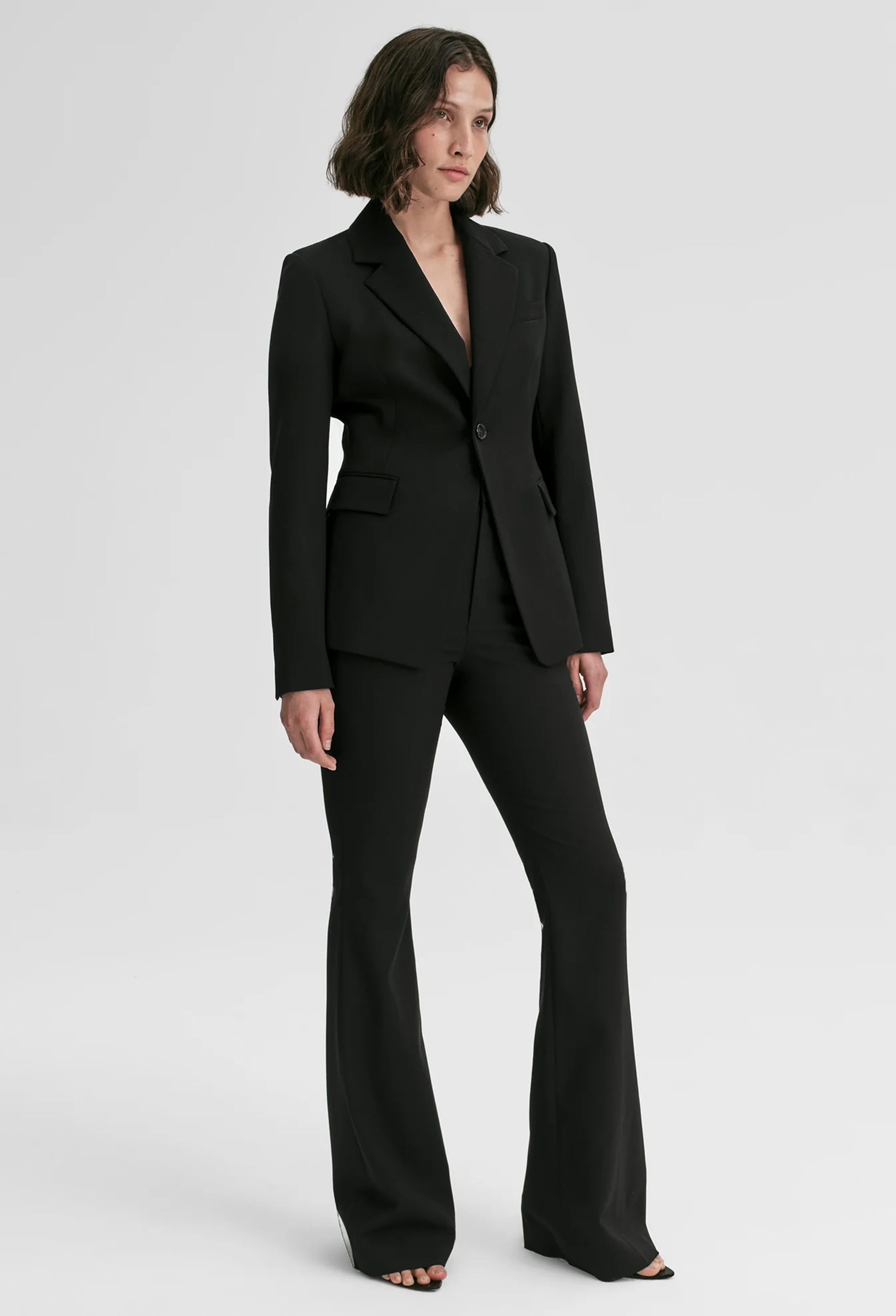 Woman wearing a black suit on a white background