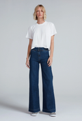a model wearing a white tee and wide leg dark jeans on a white background
