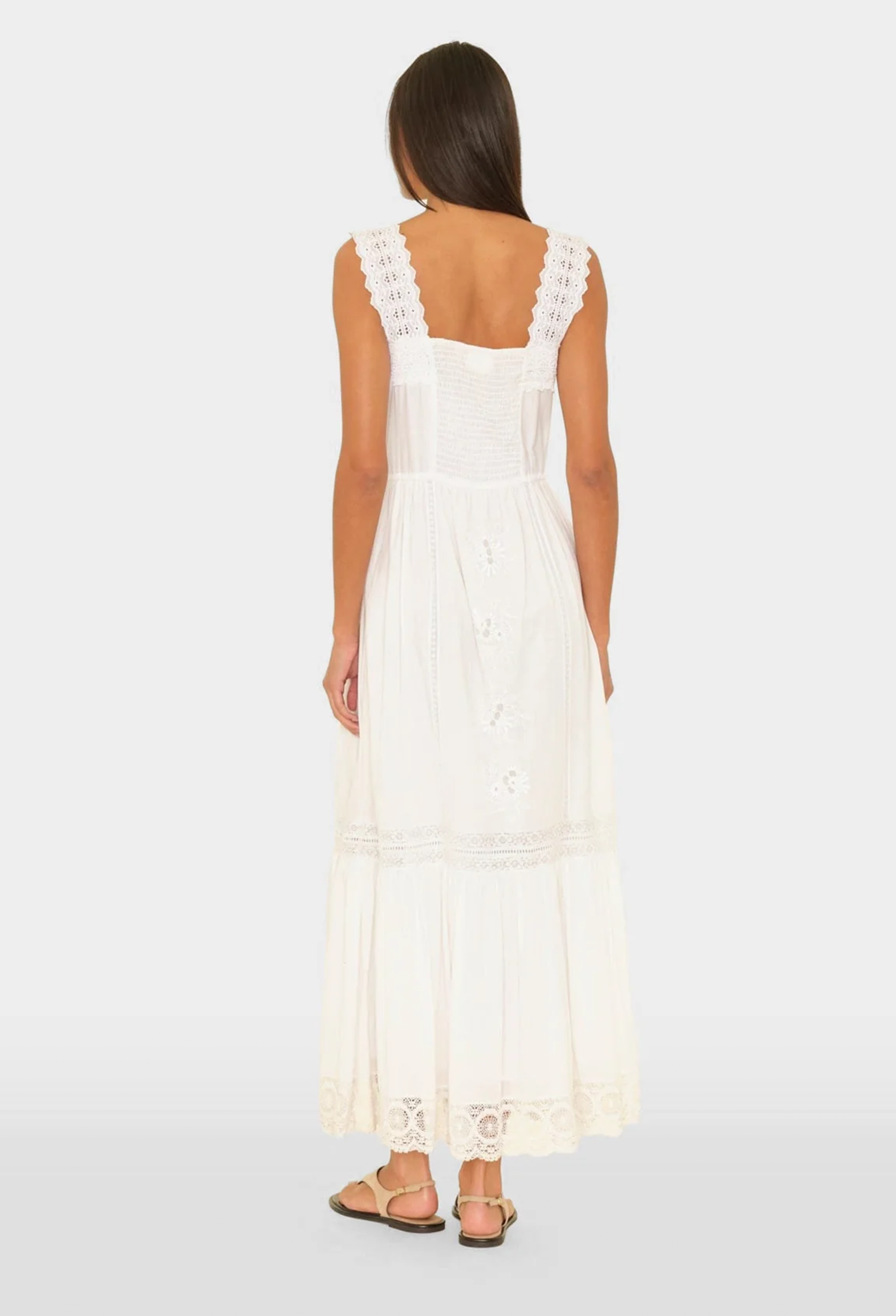 Woman wearing a white lace dress on a white background