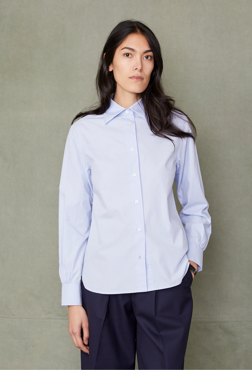Woman wearing a light blue shirt against a plain background
