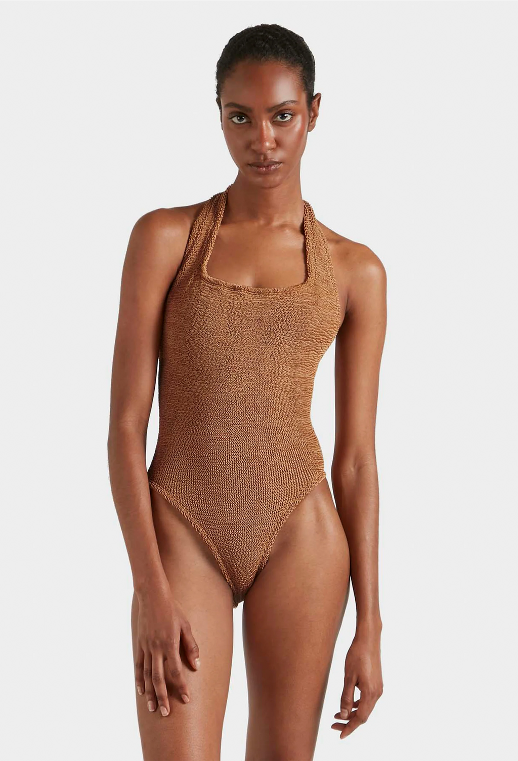 Woman wearing a brown textured swimsuit against a white background