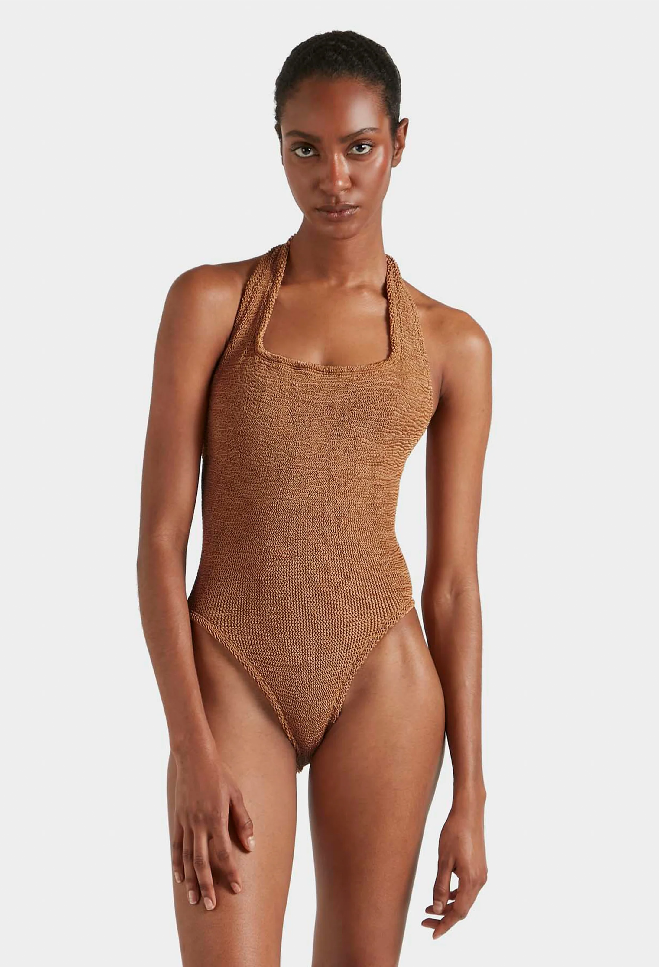 Woman wearing a brown textured swimsuit against a white background