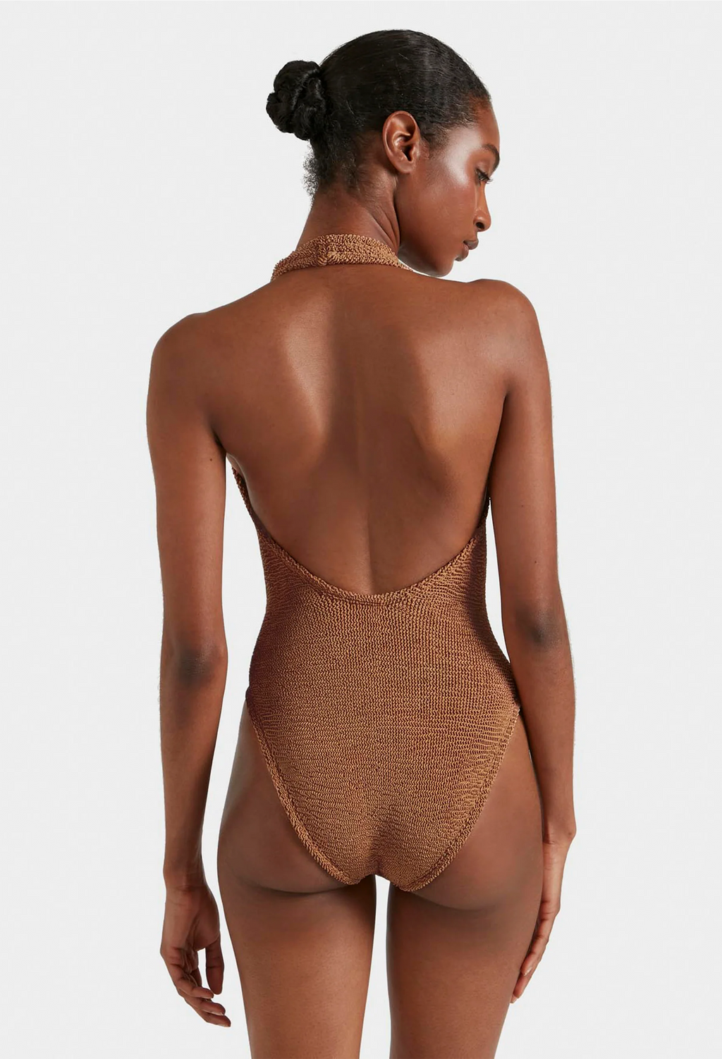 Woman wearing a brown textured swimsuit against a white background