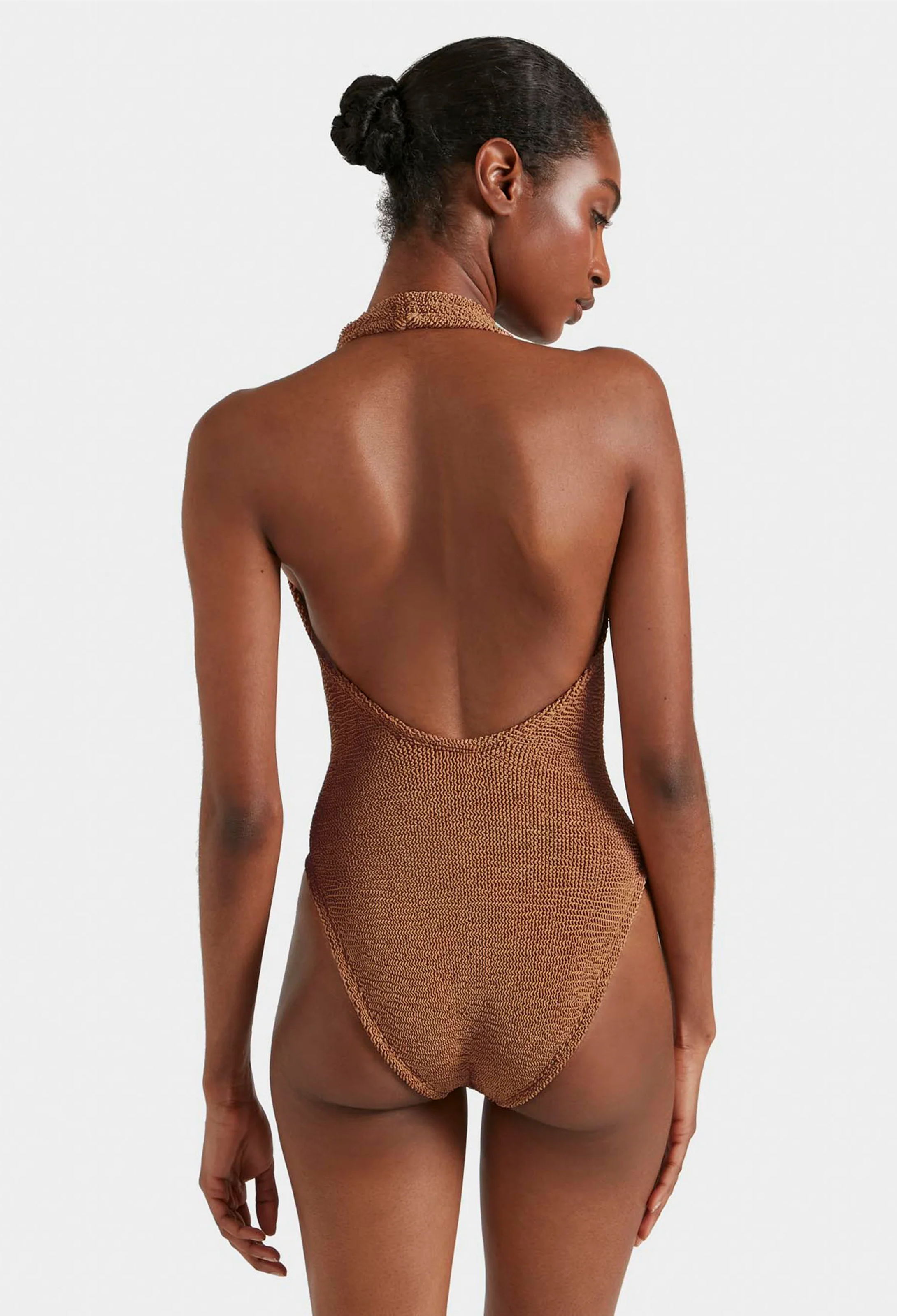 Woman wearing a brown textured swimsuit against a white background