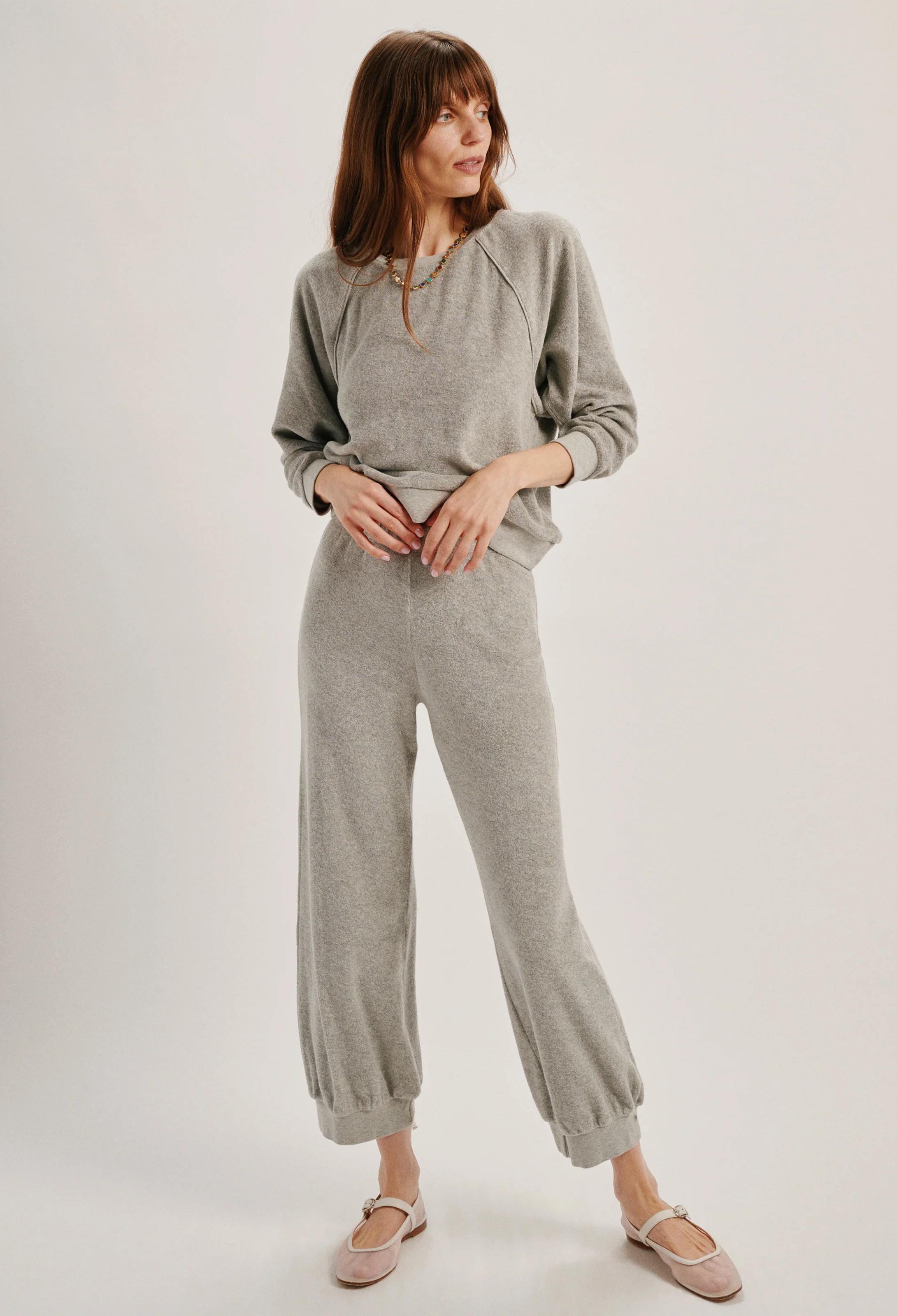 Woman wearing a gray outfit on a white background