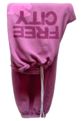 Pink sweatpants with 'FREE CITY' text on a white background