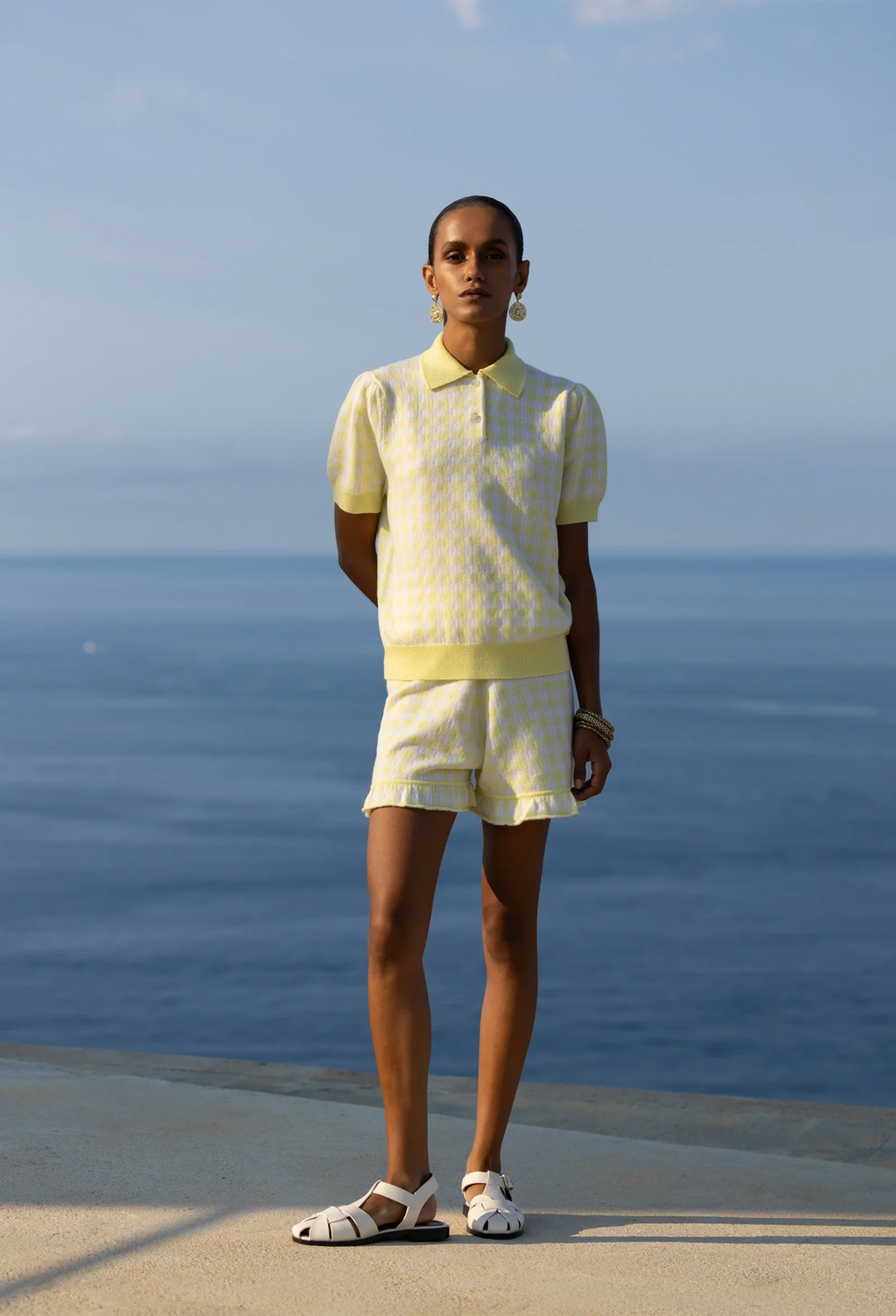 Person wearing a yellow outfit standing by the ocean
