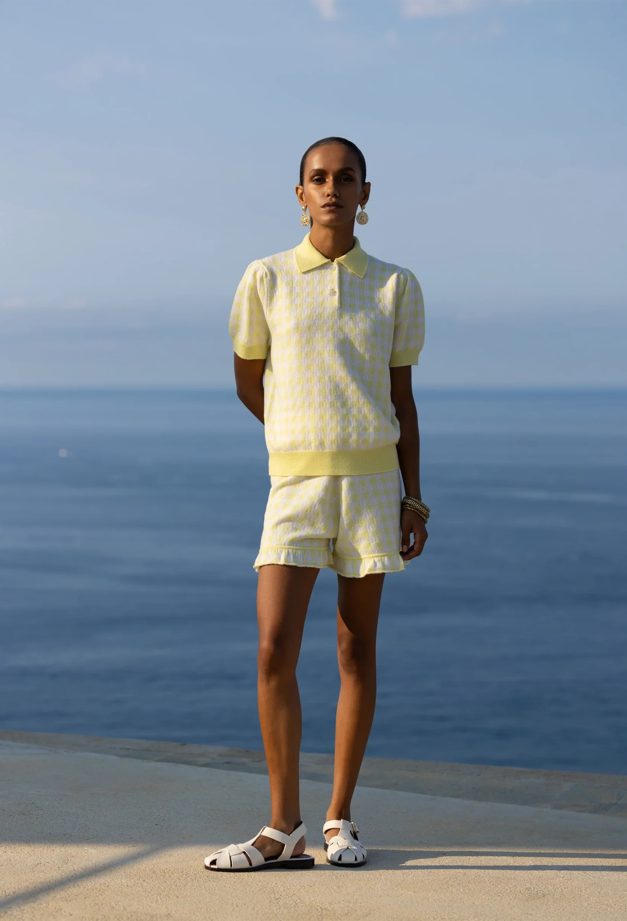 Person wearing a yellow outfit standing by the ocean