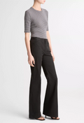 Person wearing a striped shirt and black wide-leg pants on a white background