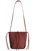red leather handbag with a long strap on a white background