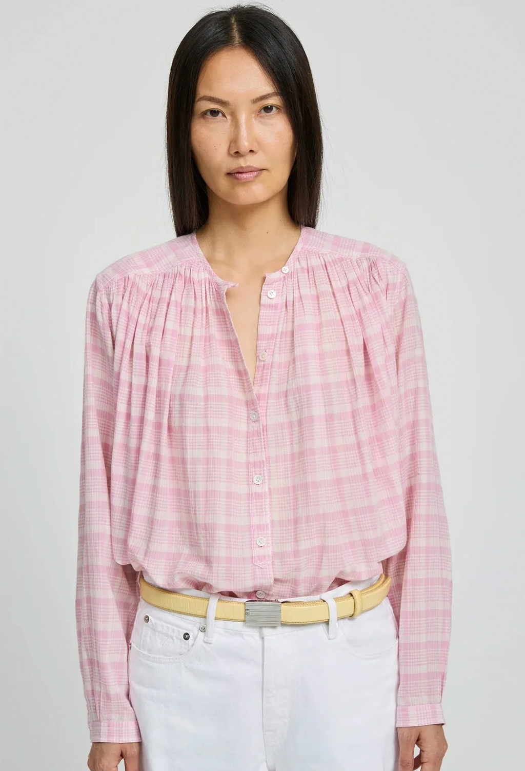 Woman wearing a pink checkered blouse with a white background