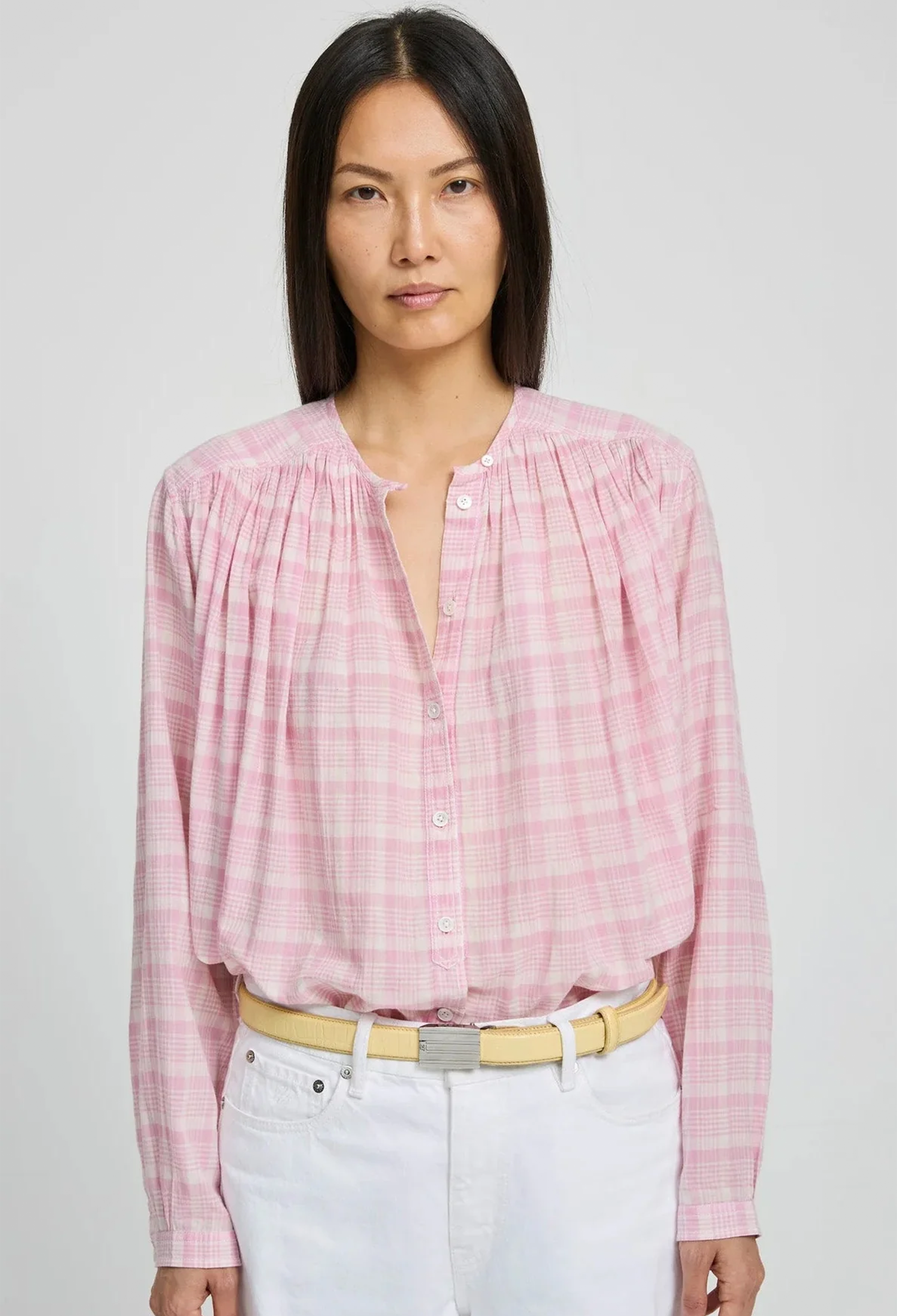 Woman wearing a pink checkered blouse with a white background