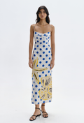 Woman wearing a white dress with blue and yellow floral patterns on a white background