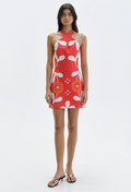Woman wearing a red dress with white floral pattern on a white background