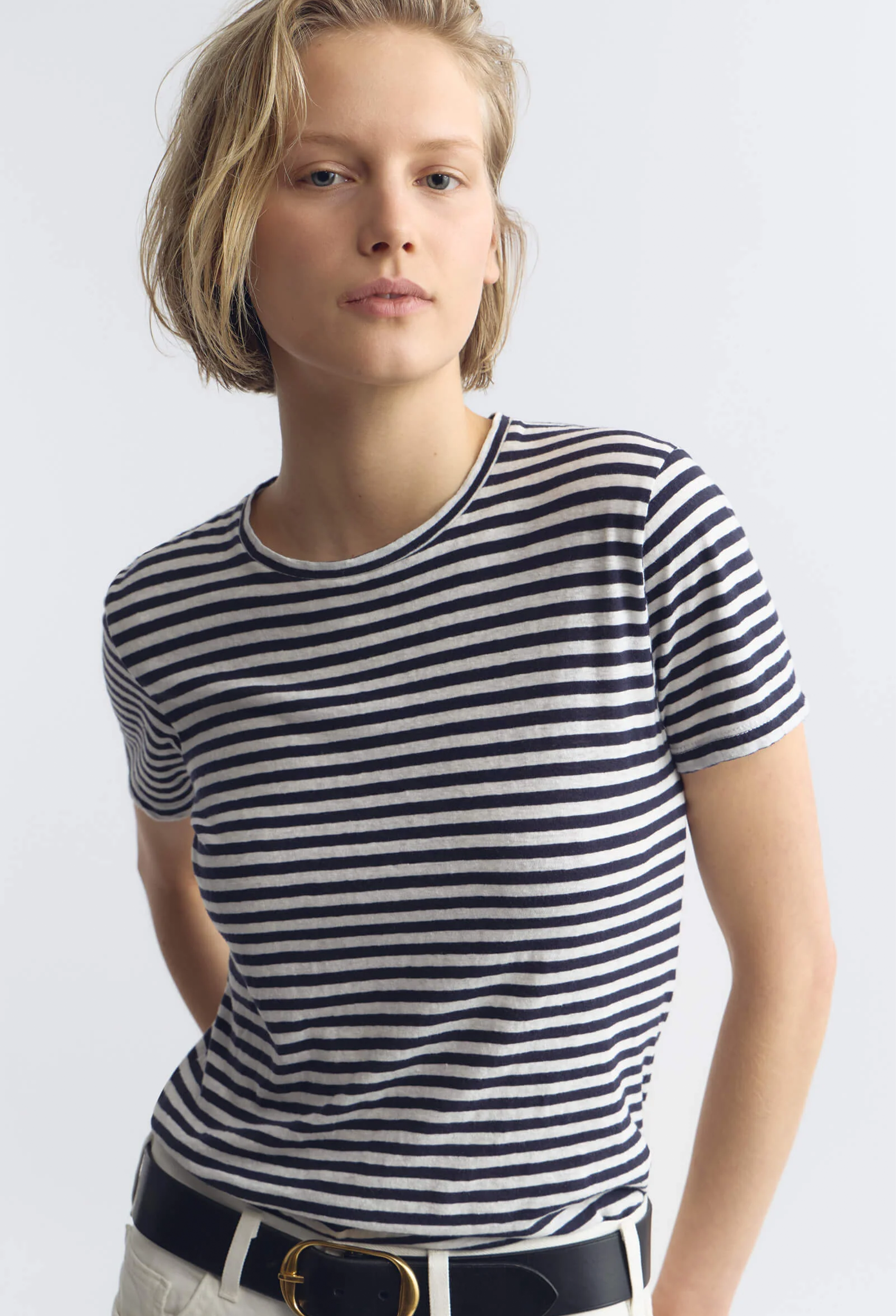 Person wearing a blue and white striped shirt on a plain background