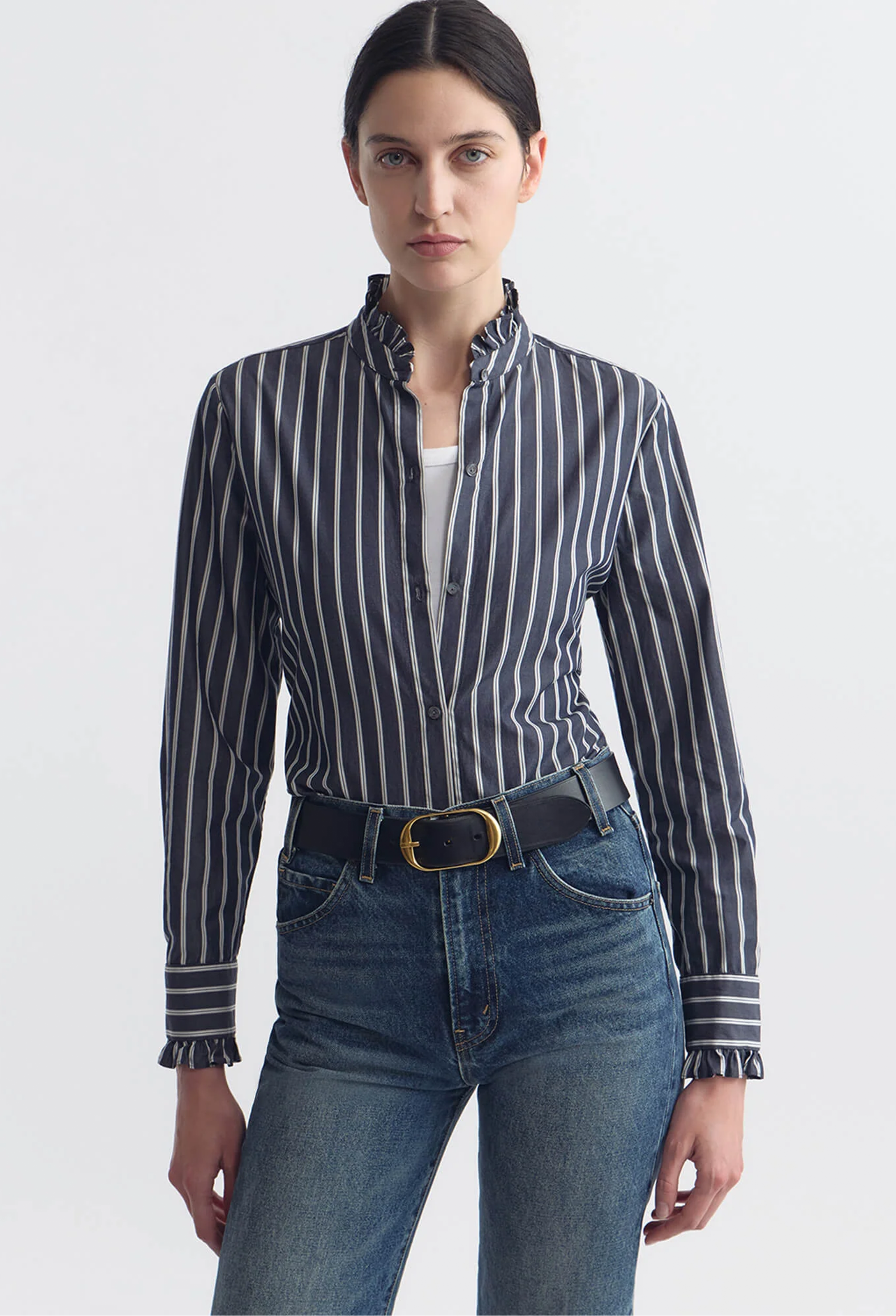 Woman wearing a striped shirt and jeans on a white background