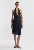 model wearing a black silk tank and matching skirt with lace hem on a white background