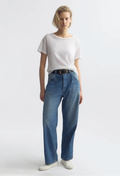 Person wearing a white t-shirt and blue jeans on a plain background