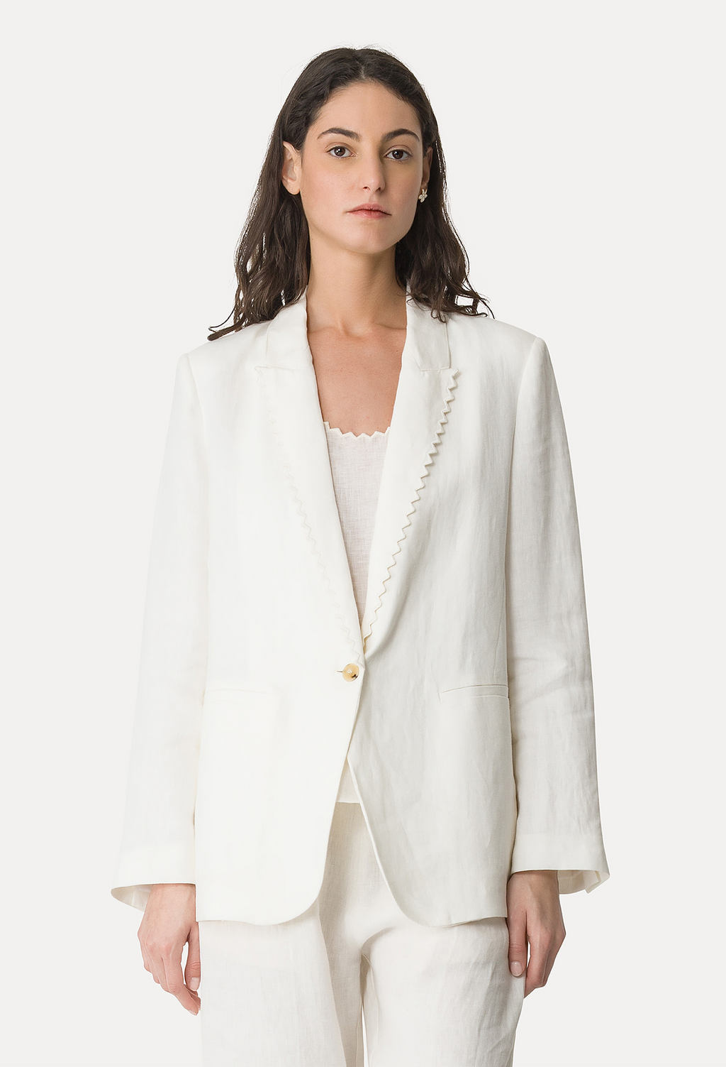 Woman wearing a white blazer with a plain background