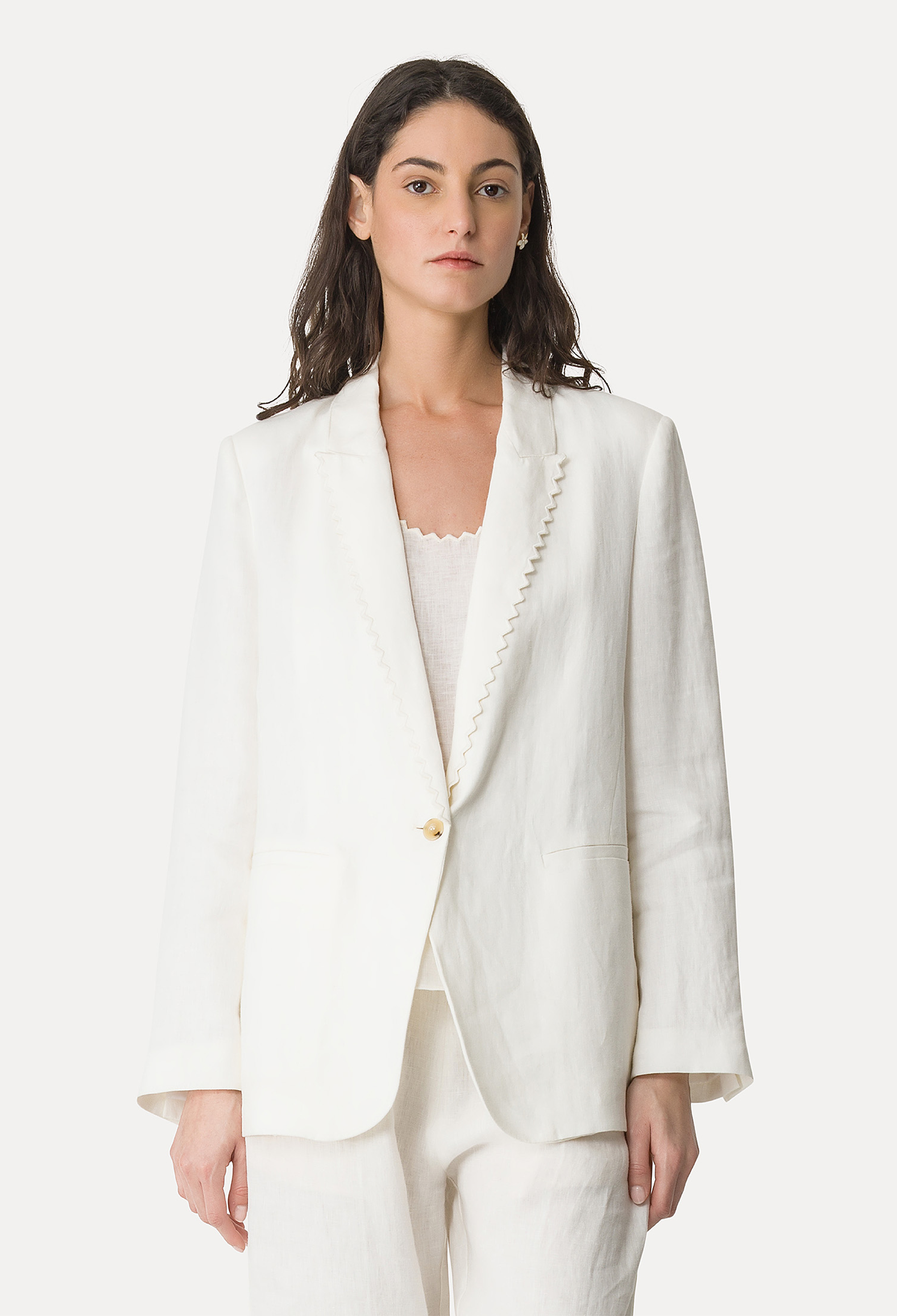 Woman wearing a white blazer with a plain background