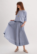 Woman wearing a light blue dress with a plain background